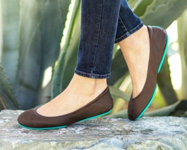 model wearing blue jeans and chocolate brown tieks flats