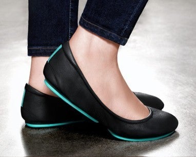 Close up of a woman wearing Matte Black Tieks leather ballet flat shoes.