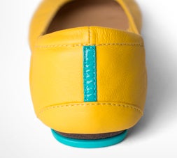 the heel of a pair of mustard yellow tieks flats