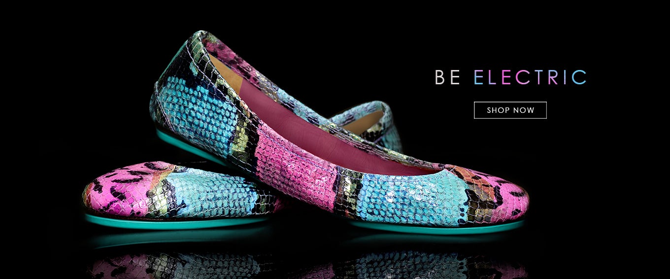 electric snake print tieks flats in front of a black background