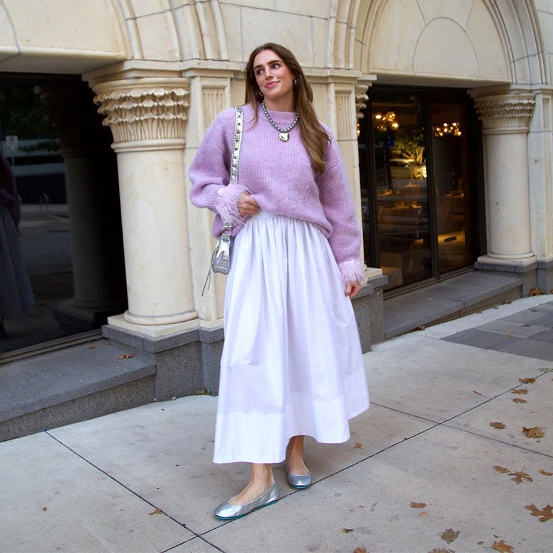 woman in a lavender sweater, white maxi skirt, and silver tieks ballet flats